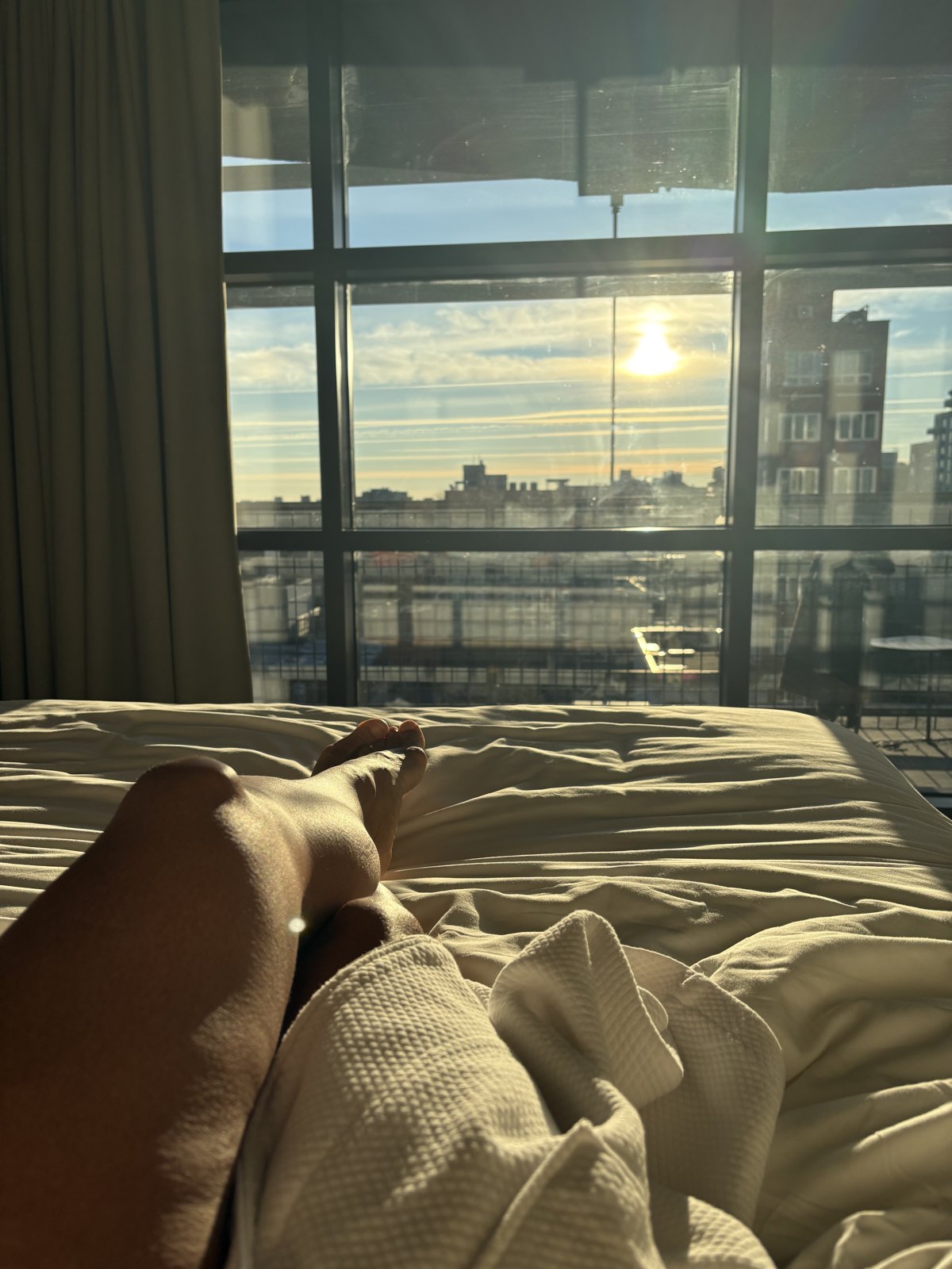 Morning sun through a city window, bare feet in golden light.