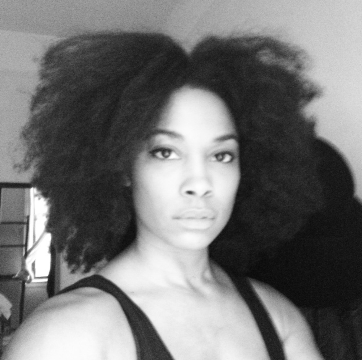Natural hair portrait, black and white, eyes straight into the lens.